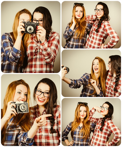 Funny hipster girls taking pictures with an old camera - Stock Photo